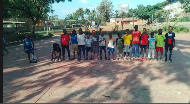 A group of junior players posing together on a court at the Manyatta Arab Junior Open Tournament.