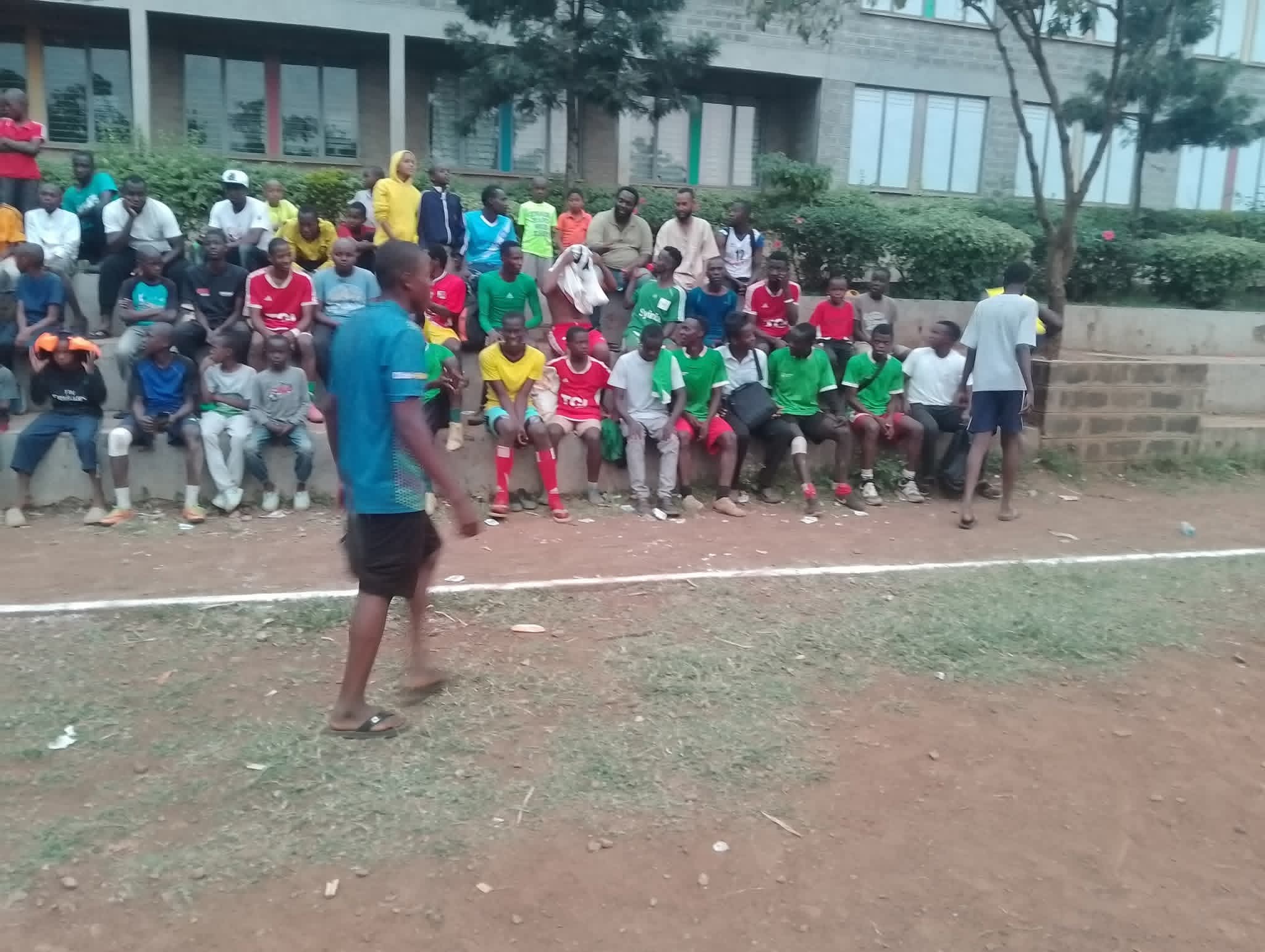 A crowd of spectators, including players and families, watching a match at the Inter-Masjid Football Tournament in Kisumu.