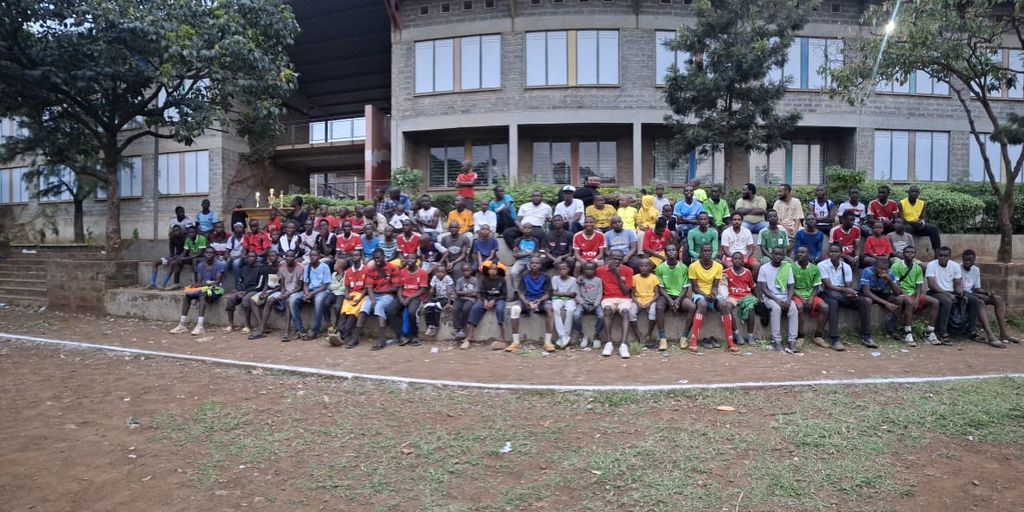 A large group photo of players and organizers seated together at the Inter-Masjid Football Tournament in Kisumu.