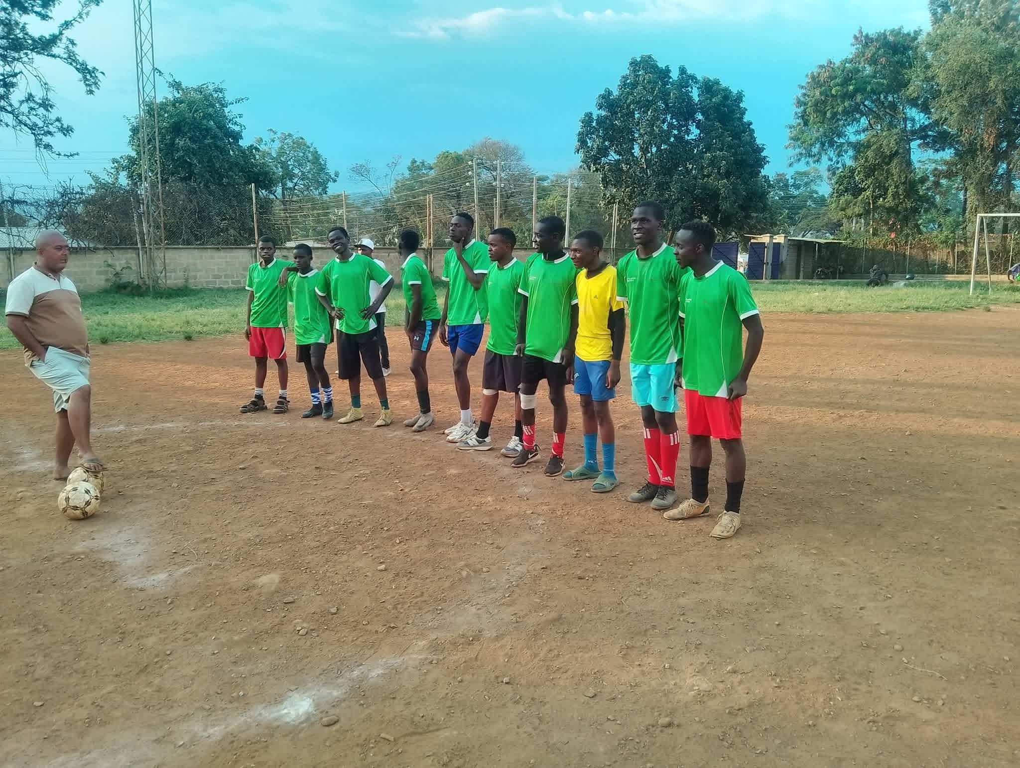 A team in green jerseys lined up on the pitch with their coach at the Inter-Masjid Football Tournament in Kisumu.